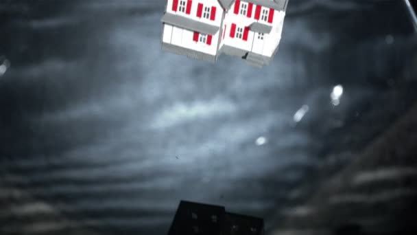 Casa modelo miniatura cayendo en aguas grises — Vídeo de stock