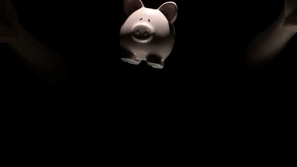 Mans handen gooien roze piggy bank — Stockvideo