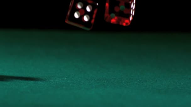 Red dice falling and bouncing on green table — Stock Video