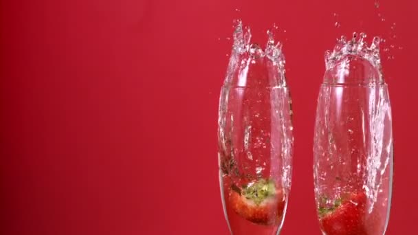 Morangos caindo em flautas de champanhe — Vídeo de Stock