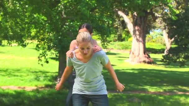 Young mother giving her daughter a piggyback — Stock Video