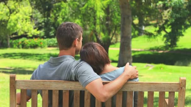 Amante jovem casal sentado em um banco — Vídeo de Stock