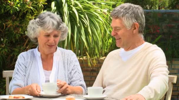 Ώριμο ζευγάρι που έχοντας καφέ στον κήπο — Αρχείο Βίντεο