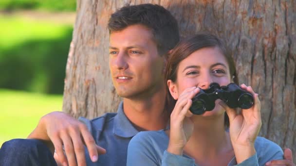 Jeune couple regardant à travers les jumelles — Video