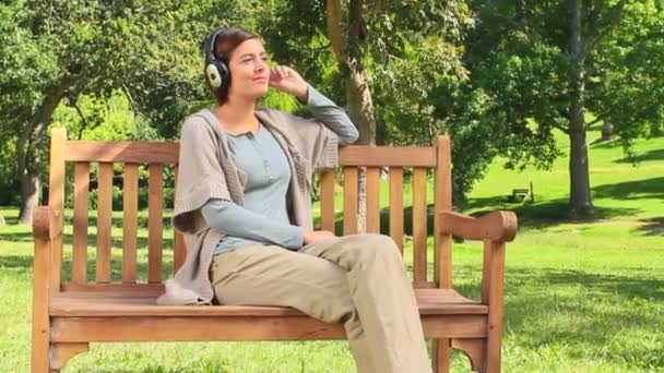 Mujer joven escuchando música al aire libre — Vídeo de stock