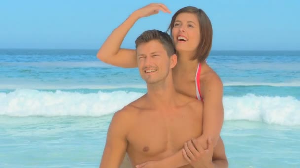 Young man giving his smiling girlfriend a piggyback — Stock Video