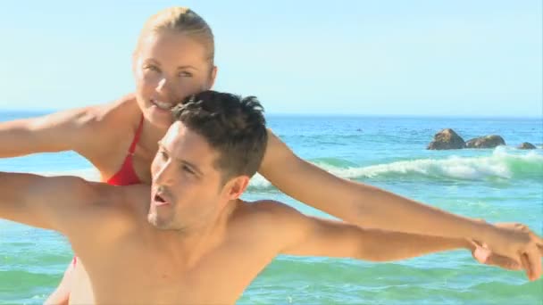 假装飞在海滩上的情侣 — 图库视频影像