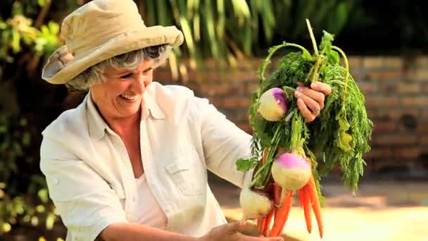 Mulher madura com vegetais de raiz — Vídeo de Stock