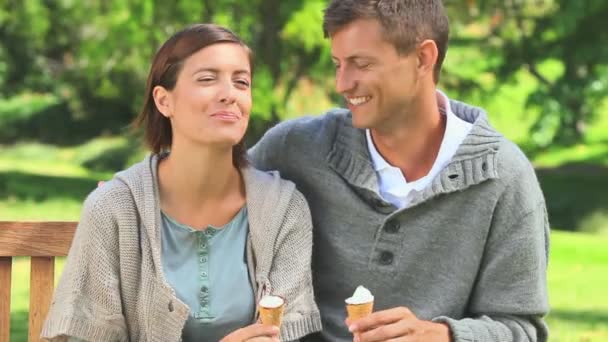 Young couple eating icecream outdoors — Stock Video