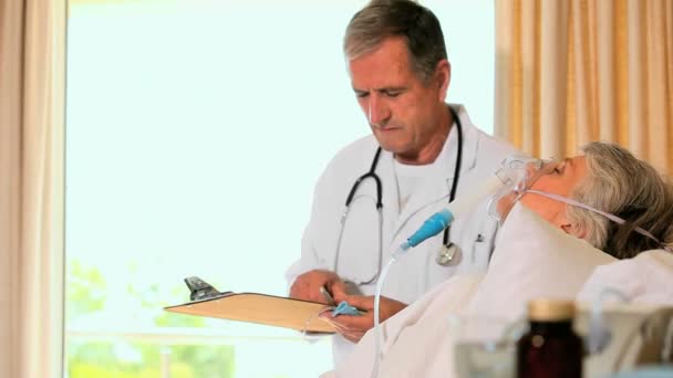 Doctor attending to woman in hospital bed — Stock Video