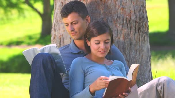 Young couple reading outdoors — Stock Video