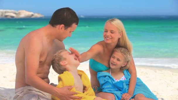 Casal secando seus filhos em uma praia — Vídeo de Stock