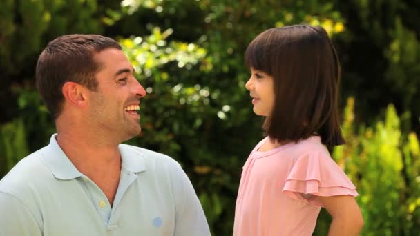 Маленькая девочка разговаривает со своим отцом — стоковое видео