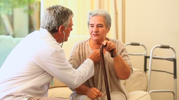 Médico examinando al paciente con un estetoscopio — Vídeos de Stock