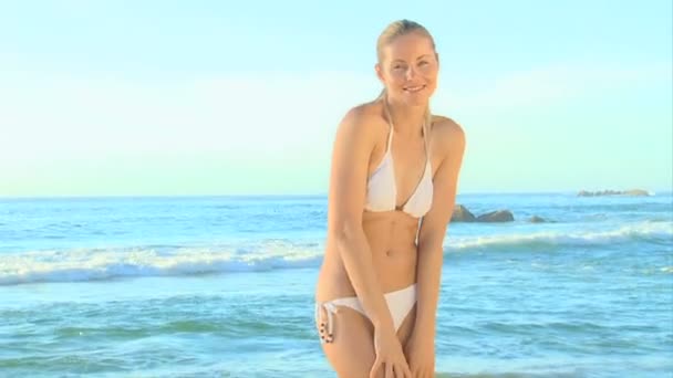 Blonde vrouw poseren met haar rug naar de zee — Stockvideo