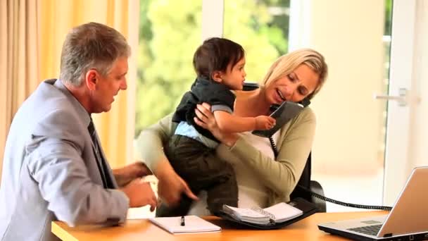 Kadının bebeği kucağına ile ofis işleri yapmak için mücadele — Stok video