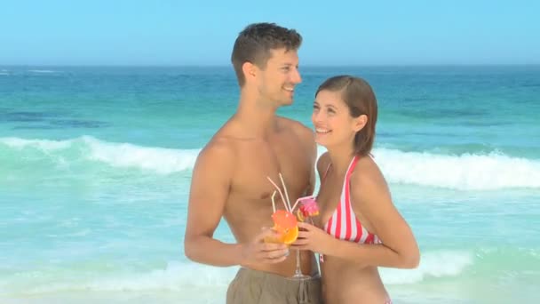 Schönes Paar trinkt an einem Strand — Stockvideo