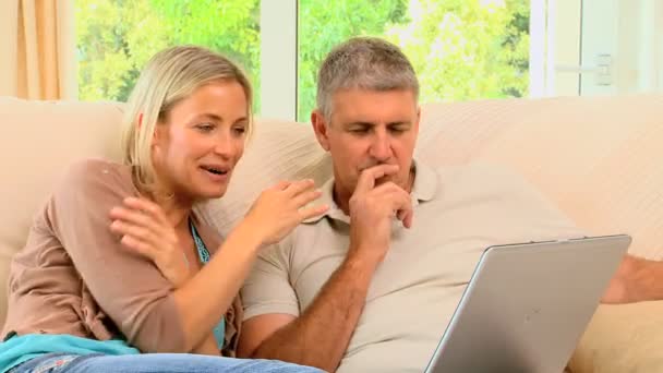 Привлекательная пара смотрит и смеется над ноутбуком — стоковое видео