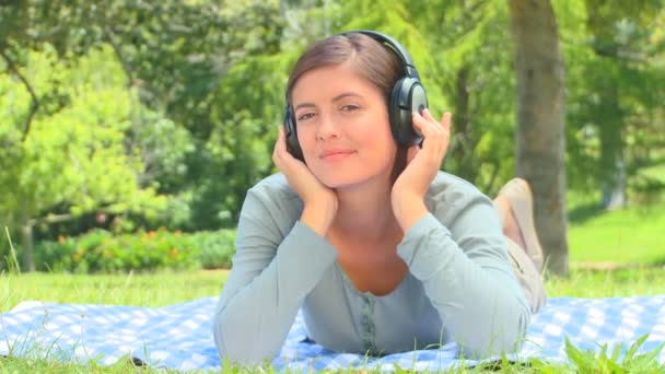 Молодая женщина слушает музыку на улице — стоковое видео