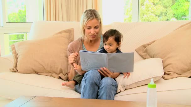 Moeder en baby kijken naar pictrure boek — Stockvideo