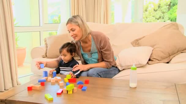 Jonge moeder die haar baby laten zien hoe blokken in elkaar passen — Stockvideo