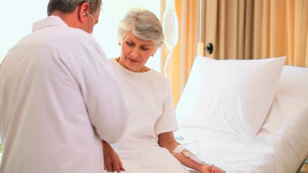 Médecin soignant une femme dans un lit d'hôpital — Video