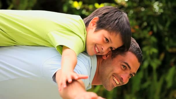 Man vliegtuigen met zijn zoon spelen op zijn rug — Stockvideo