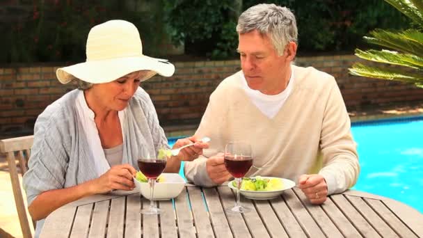 Bir yemek şarap ile yüzme havuzunun kenarında olan Olgun çift — Stok video