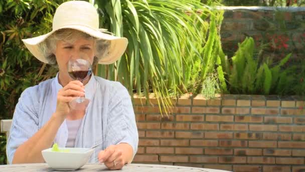 Volwassen vrouw drinken van een glas rode wijn buitenshuis — Stockvideo