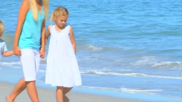 Мати на пляжі з маленькими дітьми — стокове відео