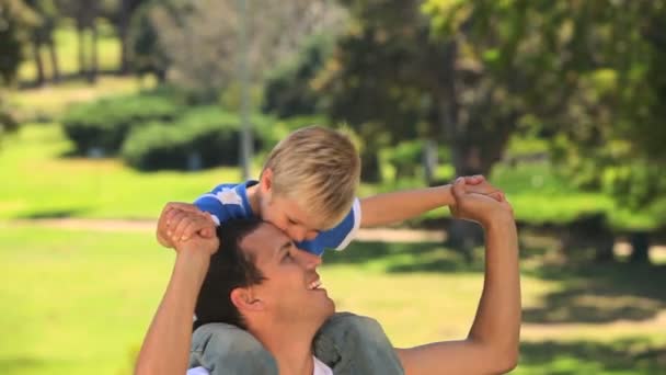 Kleiner Junge sitzt auf den Schultern seines Vaters — Stockvideo