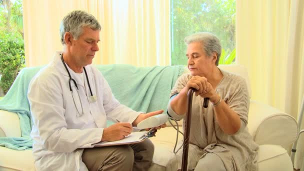 Лікар приймає нотатки під час і приймає кров'яний тиск — стокове відео