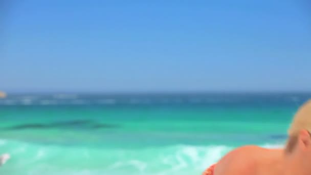 Привлекательная блондинка играет с пляжным мячом — стоковое видео
