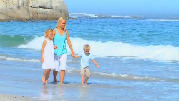 Linda familia joven caminando en la playa — Vídeos de Stock