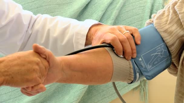 Doctor taking the blood pressure of his patient — Stock Video