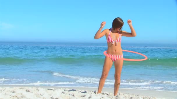 Woman playing with hula hoop on the beach — Stock Video