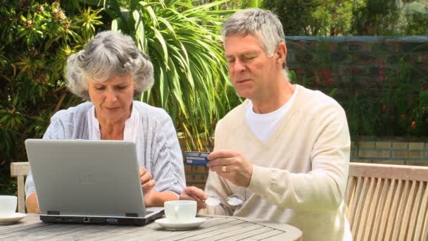 Mature couple buying on-line using a credit card — Stock Video