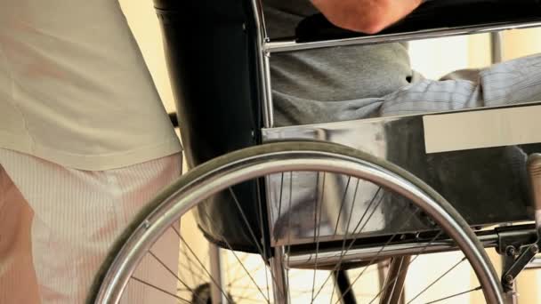 Man in wheelchair looking through the window — Stock Video