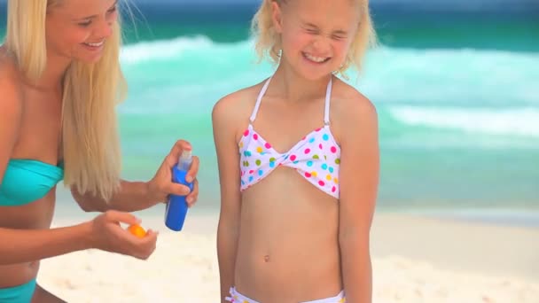 Mother putting suncream on her daughter — Stock Video