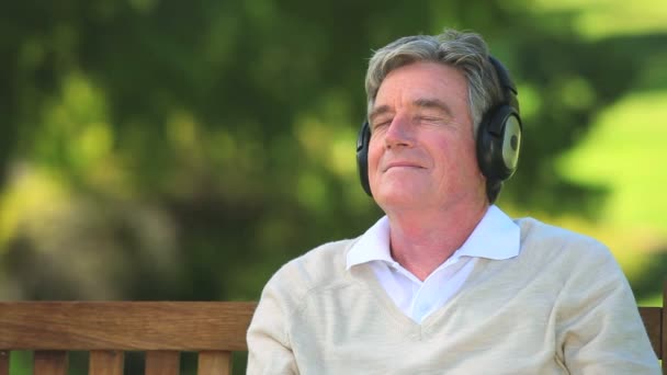 Зрелый человек слушает музыку — стоковое видео