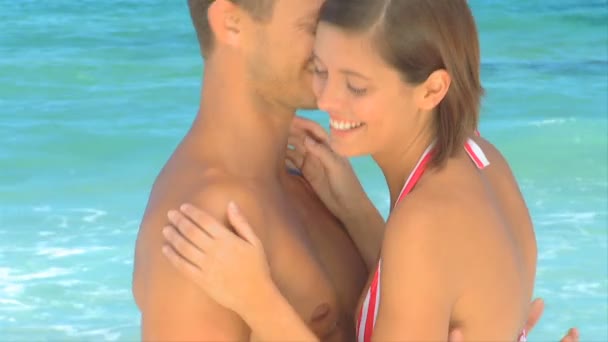 Ελκυστικό ζευγάρι αγκαλιάζει σε μια παραλία — Αρχείο Βίντεο