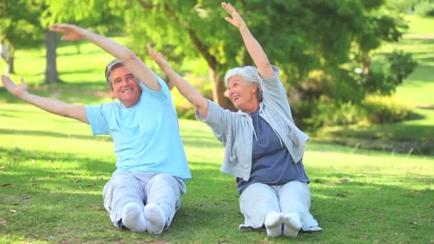 Mature couple doing their stretches outside — Stock Video