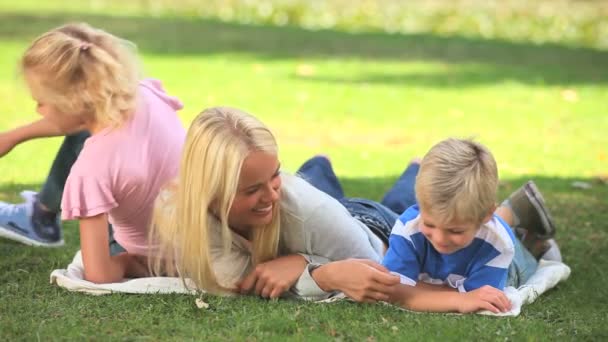 Молодая женщина и двое ее детей веселятся — стоковое видео