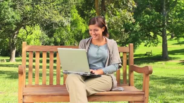 Ung kvinna chattar på hennes laptop — Stockvideo