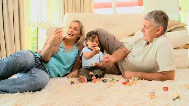 カップルのカーペットの上に赤ちゃんと遊ぶこと — ストック動画