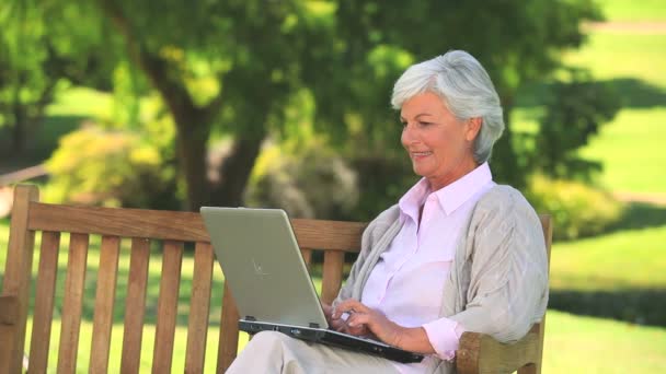 Zralá žena surfování na její laptop venku — Stock video