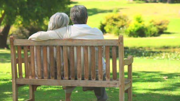 Mature couple sitting talking outdoors — Stock Video