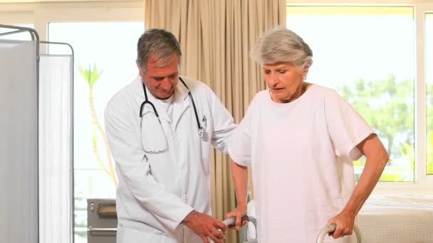 Doktor v nemocnici pomáhá žena chodit — Stock video