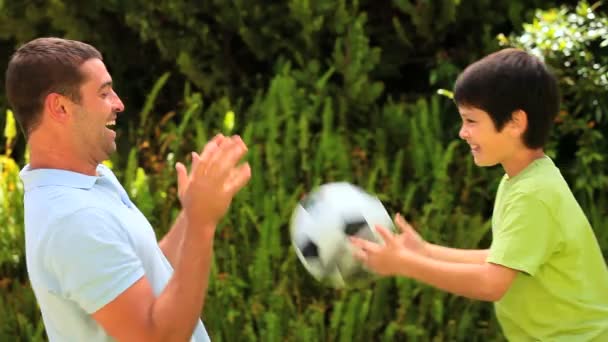Мальчик и его отец играют в футбол — стоковое видео
