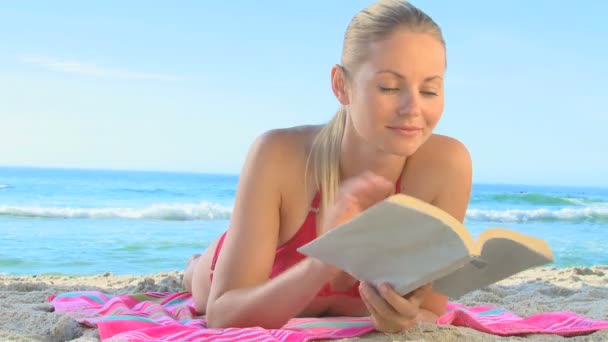 Гарненька блондинка читає роман — стокове відео